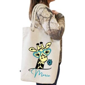 Tote bag blanco de algodón con asa de cuerda blanca y personalizado con la imagen "cuqui" de una jirafa con gafas y una flor de color azul conjuntamente con el nombre que se quiera personalizar tambien en el mismo color azul.