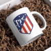Taza blanca con diseño de escudo deportivo en rojo, blanco y azul del Club Atlético de Madrid sociedad anónima deportiva