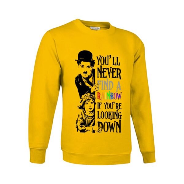 Sudadera amarilla con estampado en blanco y negro del personaje Charlot de Charlie Chaplin y una niña, con la frase inspiradora 'YOU'LL NEVER FIND A RAINBOW IF YOU'RE LOOKING DOWN' en colores del arcoíris