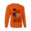 Sudadera naranja con estampado en blanco y negro del personaje Charlot de Charlie Chaplin y una niña, con la frase inspiradora 'YOU'LL NEVER FIND A RAINBOW IF YOU'RE LOOKING DOWN' en colores del arcoíris