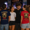 Grupo de amigos con camisetas de El Barrio Gira 30 Córdoba 2027 durante un concierto